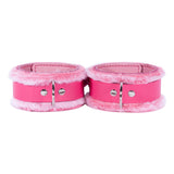 a pair of pink leather cuffs with metal clasps