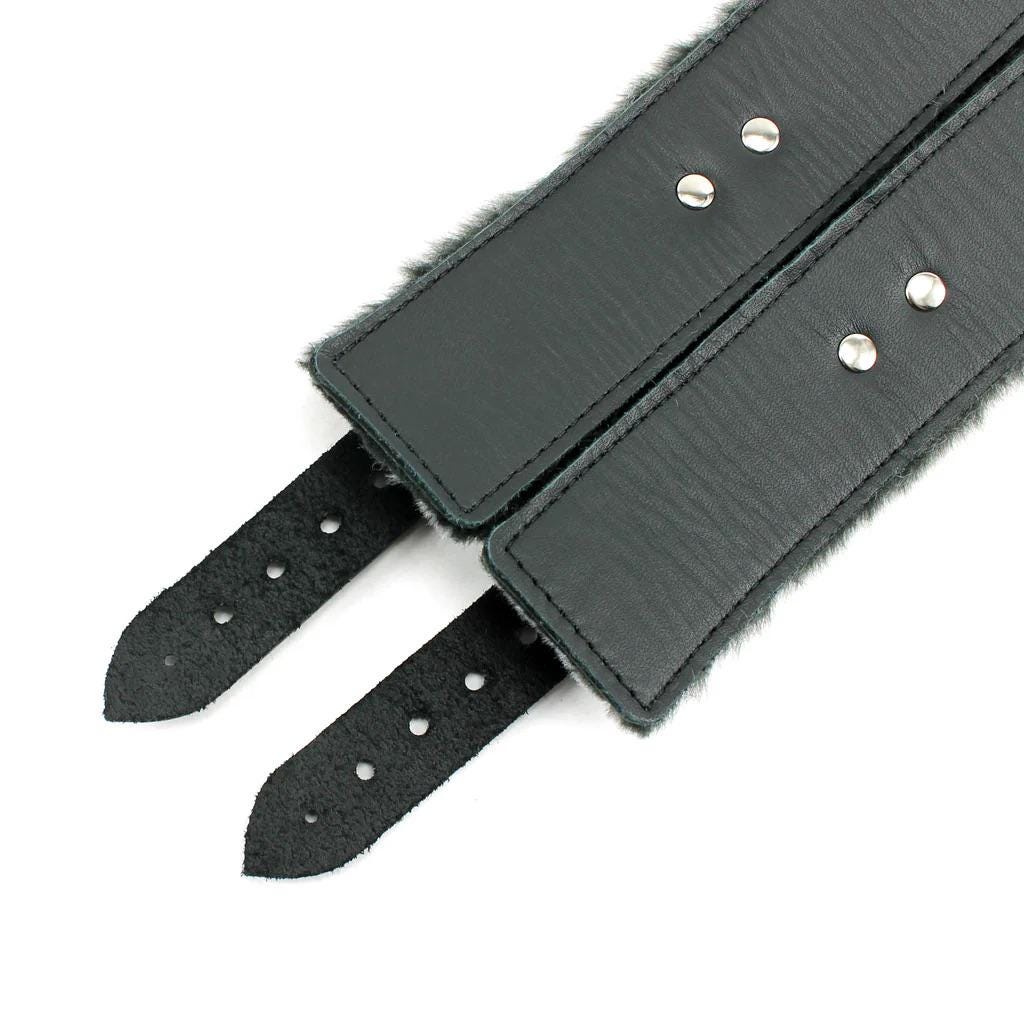 a pair of black leather belts with metal rivets