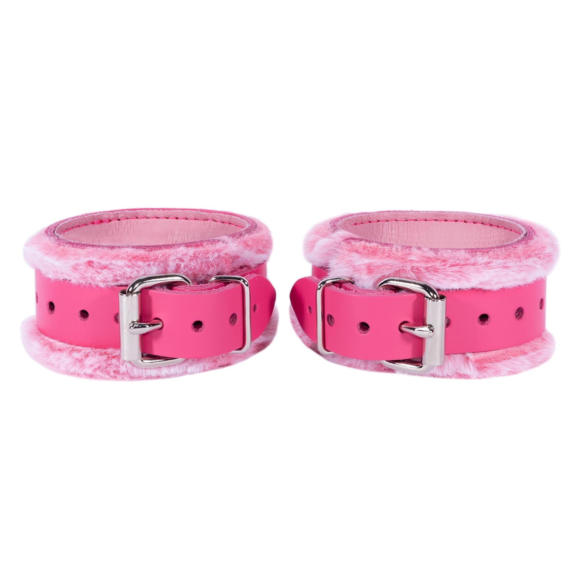 a pair of pink leather cuffs with metal buckles